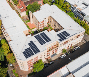 Aerial drone view of arriva’s Chippendale apartments in Sydney featuring rooftop solar panels, showcasing sustainable living and community-focused design.